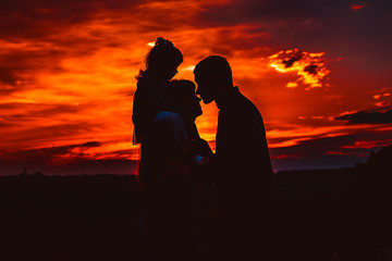 Happy family, father, mother, son and daughter in nature, sunset