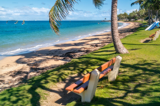 Relax on a bench at the tropical beach at Anse Vata Bay in Noumea, New Caledonia, French Polynesia, South Pacific Ocean.