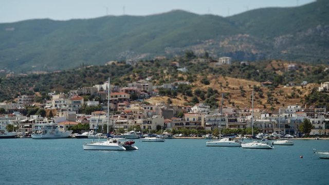 Navegando por la costa griega en verano, mar azul, bonitos pueblos y casas a la distancia
