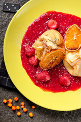 Crepes With Berries. pancakes with fresh berries, raspberries, strawberry, seabuckthorn and orange. Yummy pancake on the table, top view. Russian kitchen