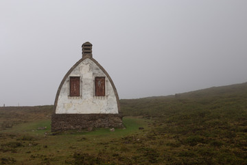 Abandoned hut in fog in the mountain