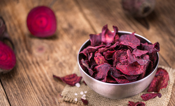 Beetroot Chips on an old wooden table (selective focus)