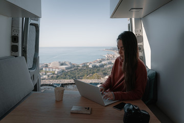 Woman sitting in vehicle looking at view while working