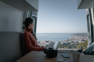 Woman sitting in vehicle looking at view while working