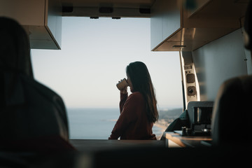 Woman sitting in vehicle looking at view