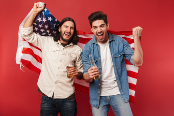 Photo of young excited guys fans holding beers and american flag