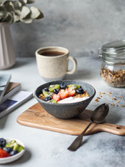 Delicious breakfast - the cup of coffee and granola with yogurt and berries and open magazine on the table. Copy space.