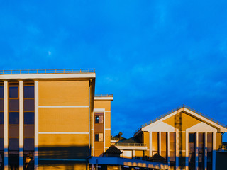 Yellow brick building at sunrise against a bright blue sky.
