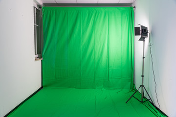 Studio with a green screen and a video light
