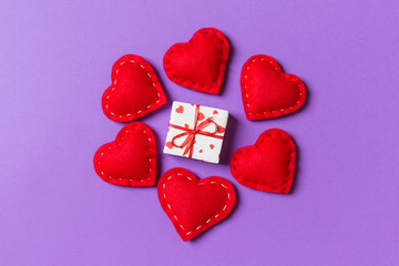 Holiday composition of gift boxes and red textile hearts on colorful background with empty space for your design. Top view of Valentine's Day concept