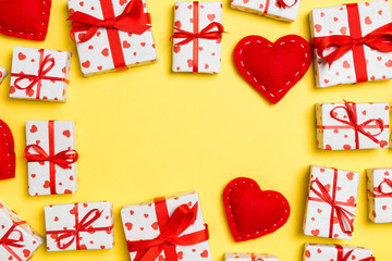 Top view of festive gift boxes and red textile hearts on colorful background with copy space. St Valentine's day concept