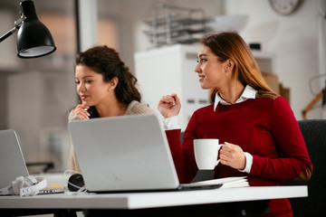 Two women working together.  Beautiful colleagues working on project. 
