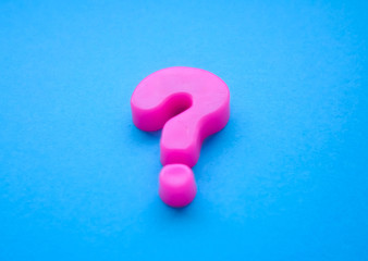 pink question mark on a blue background. Background photo with place for text.