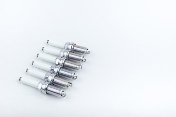 backdrop with set of 6 spark plugs on white background with copy space. car spare parts on light background