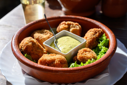 Fried whole champignons muchrooms with bread crumbs served with dip sauce