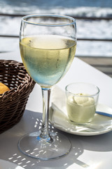 Summer holiday on sea, drinking white wine on outdoor terrace with sea view in sunny day
