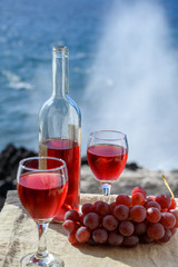 Two glasses of rose wine served outdoor with pink grapes fruits on tropical island La Palma, Canary islands, Spain with beautiful blue ocean view