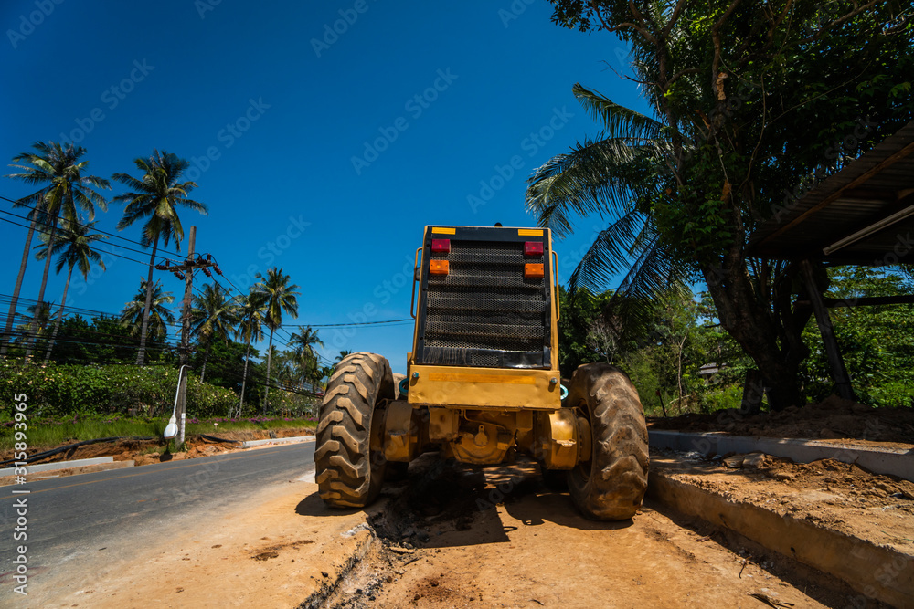 Wall mural Grader is working on road construction. Grader industrial machine on construction of new roads. Heavy duty machinery working on highway. Construction equipment. Compaction of the road.