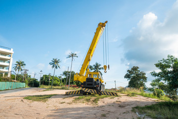 Yellow automobile crane with risen telescopic boom outdoors. Mobile construction crane on a...