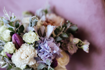 Rich bunch of pink peonies and lilac eustoma roses flowers, green leaf in glass vase. Fresh spring bouquet. Summer Background