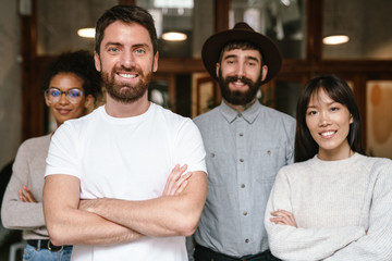 Image of multiethnic young business workers standing together at office