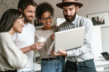 Image of multiethnic young business workers standing together at office