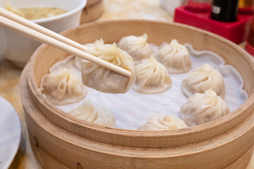 Xiao long bao soup dumpling buns with chopsticks in restaurant (Traditional Chinese food) in Taipei Taiwan