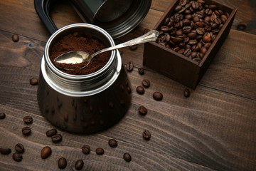 ground coffee in a coffee maker with a teaspoon on a wooden background with copy space. background...