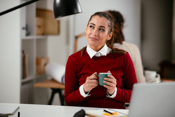 Young businesswoman drinking coffee in her office	