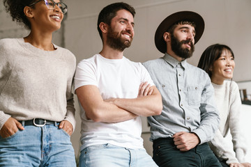 Image of multiethnic young business workers standing together at office