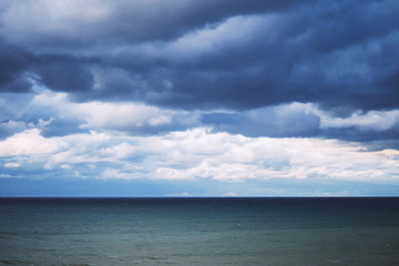 Dark clouds and waves at sea. Storm in the winter.