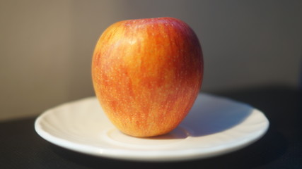 red Apple and tangerine on a white plate