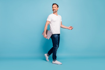 Full length body size view of his he nice attractive cheerful cheery content guy walking carrying laptop good lifestyle isolated on bright vivid shine vibrant teal green blue turquoise color