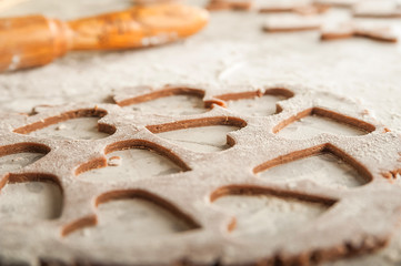 The process of making gingerbread. Flat lay flour heart dough. Texture of the dough for cookies close-up. Gingerbread dough on February 14, flour, rolling pin and copy space.