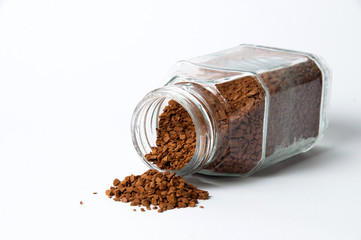 Instant coffee spills out of can on a white background