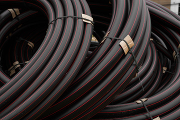 Black rubber or plastic pipes with a red lines as a construction material and equipment at building...