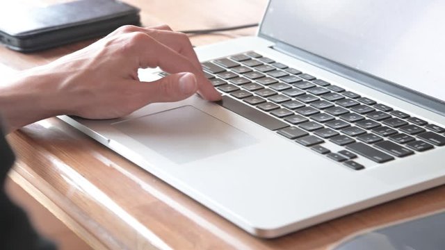 Male hand is typing on laptop, presses space bar. Man works in program. Closeup