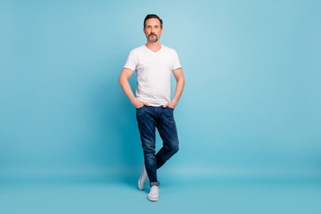 Fototapeta na wymiar Full length body size view of his he nice attractive content mature brunette guy posing holding hands in pockets isolated on bright vivid shine vibrant teal green blue turquoise color background