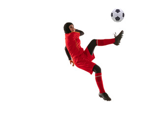 Fototapeta na wymiar Arabian female soccer or football player isolated on white studio background. Young woman kicking ball in jump, catched in air, training in motion, action. Concept of sport, hobby, healthy lifestyle.