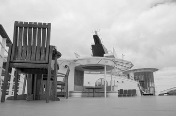 Relaxing on outdoor promenade with sun umbrellas and deck chairs with ocean views on luxury cruise...