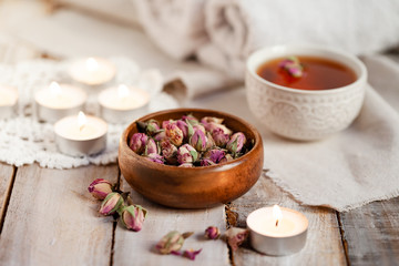 Obraz na płótnie Canvas Concept of spa treatment with roses. Dry flowers in a bowl, herbal tea, towel, candles as decor. Atmosphere of relax and pleasure, comfort, anti-stress and detox procedure. Luxury lifestyle. 