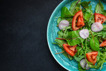 Healthy salad, leaves mix salad (mix micro greens, cucumber, tomato, onion, other ingredients). food background. copy space