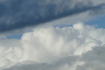 Fototapeta na wymiar Dunkle und weisse Wolken, Blauer Himmel