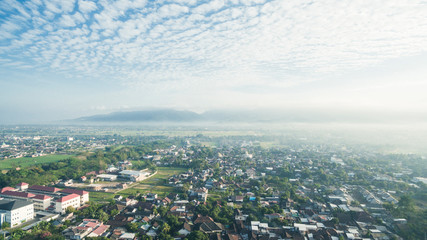 Residential neighborhood subdivision skyline Aerial shot. Top view of house Village from Drone capture. Top-down aerial drone image of a suburb in the midst of summer. Midtown of Indonesia.