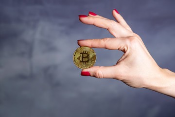 Naklejka na ściany i meble Woman hand holding bitcoin cryptocurrency. Finance concept
