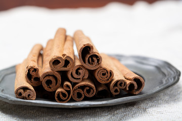 Winter food ingredient, dried aromatic cinnamon sticks on tin plate