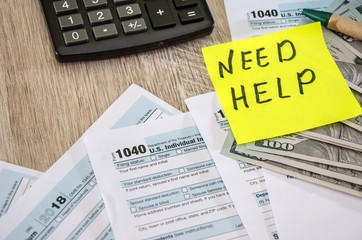 tax forms 1040, calculator, dollars and pen on the table