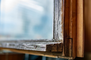 Close up view on part of old wooden window's frame construction with reflection on glass. Copy space, selective focus.