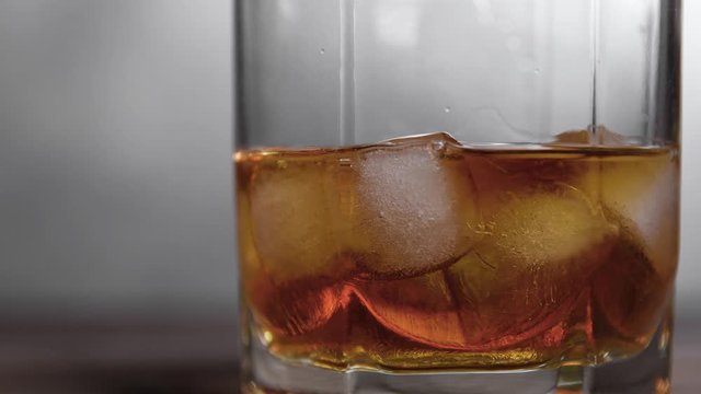 Ice melting in a glass of whiskey. close up