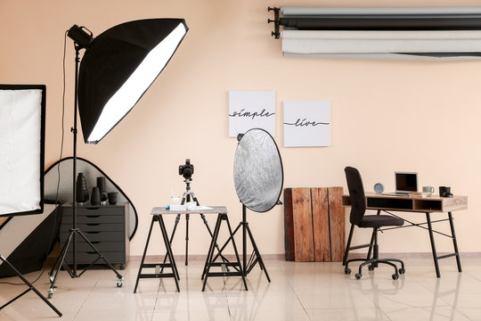 Interior of modern photo studio with professional equipment and food on table